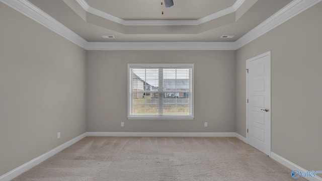 unfurnished room featuring ornamental molding, ceiling fan, a tray ceiling, and light carpet