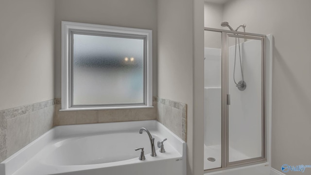 bathroom featuring a garden tub and a stall shower