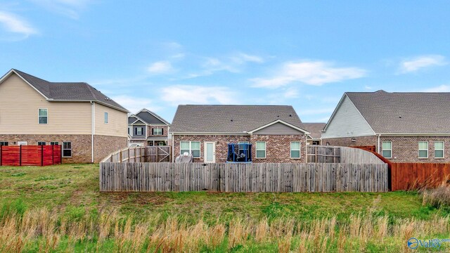 back of property featuring a fenced backyard and brick siding
