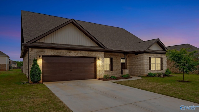view of front of property with a yard, an attached garage, driveway, and a shingled roof