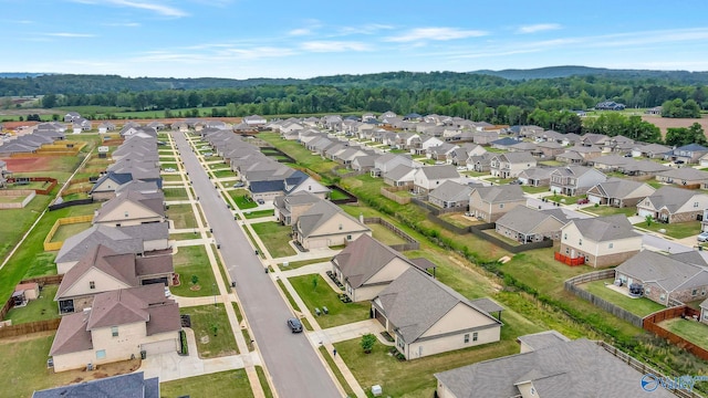 drone / aerial view featuring a residential view and a forest view