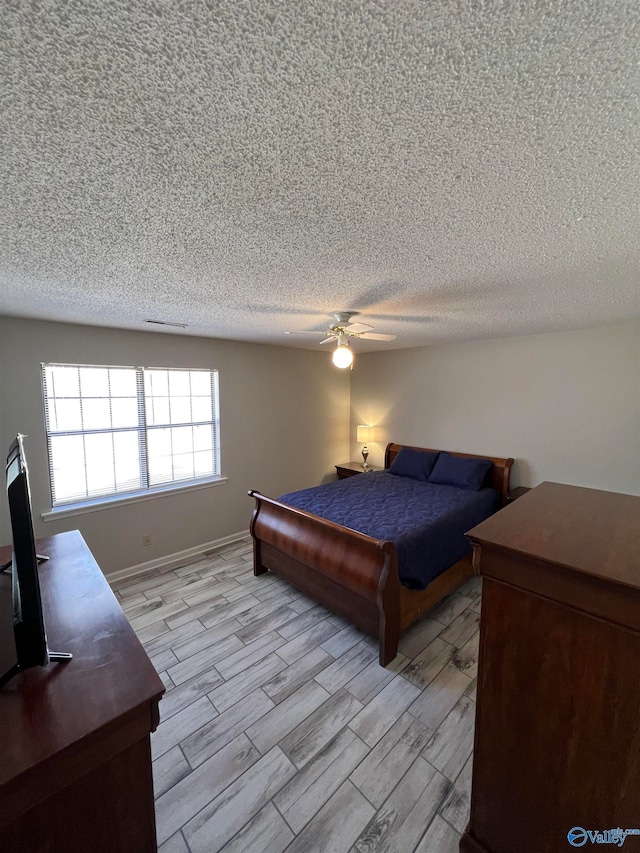 bedroom featuring a textured ceiling, ceiling fan, and light hardwood / wood-style floors