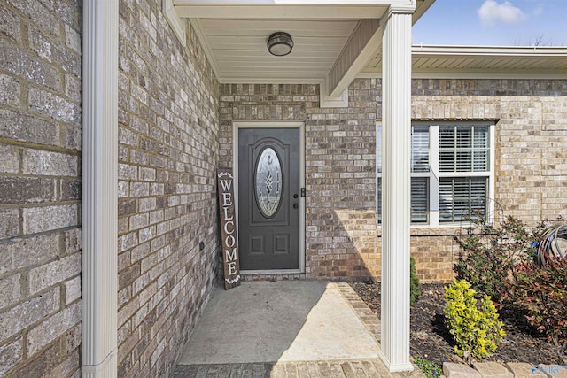 doorway to property featuring brick siding