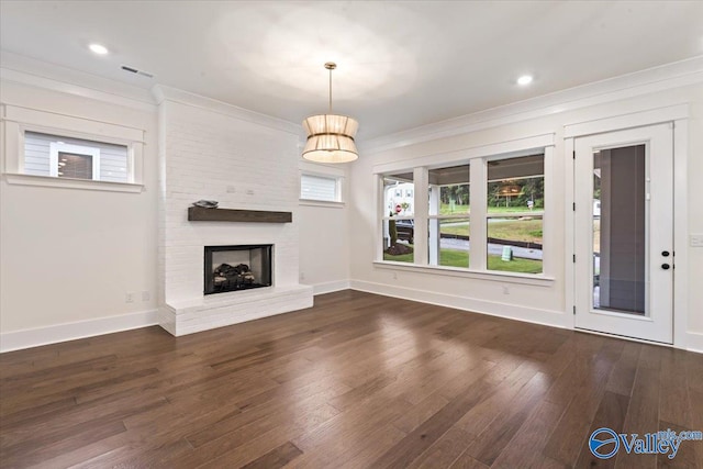 unfurnished living room with dark wood-type flooring, crown molding, and a brick fireplace