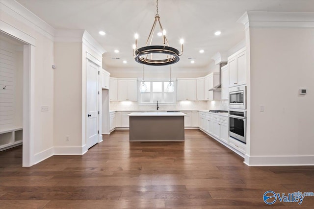 kitchen with appliances with stainless steel finishes, a center island, tasteful backsplash, and dark wood-type flooring