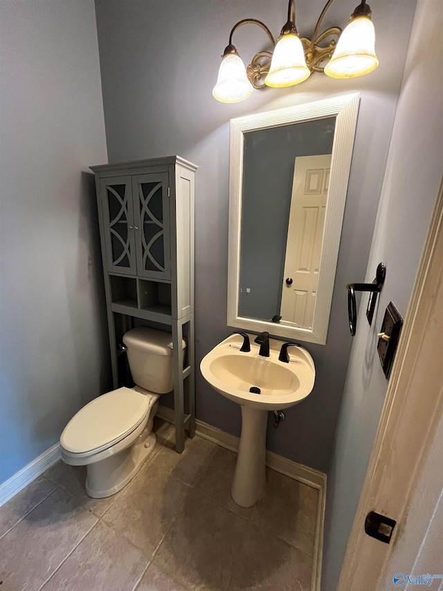 half bath featuring toilet, tile patterned flooring, and baseboards