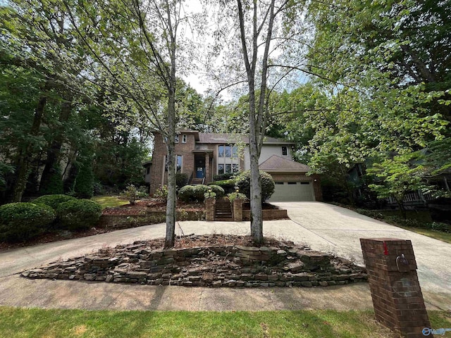 view of front of home with a garage, concrete driveway, and brick siding