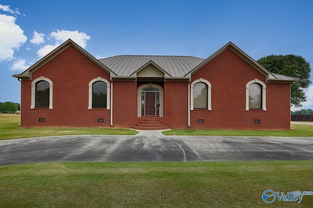 ranch-style home featuring a front yard, crawl space, brick siding, and metal roof