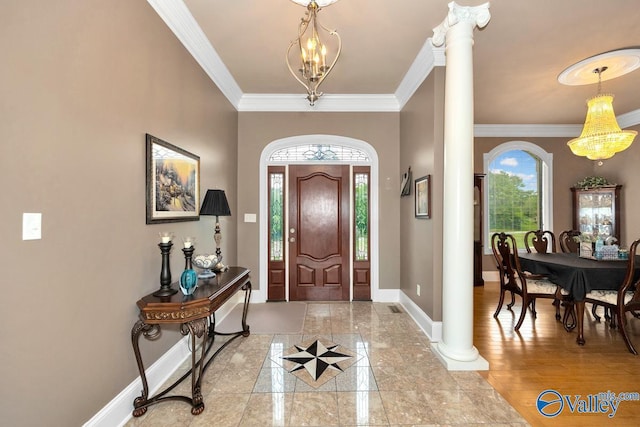 entrance foyer with crown molding, a chandelier, decorative columns, and baseboards