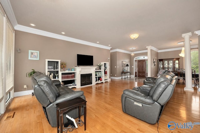 living room featuring decorative columns, crown molding, and light hardwood / wood-style flooring