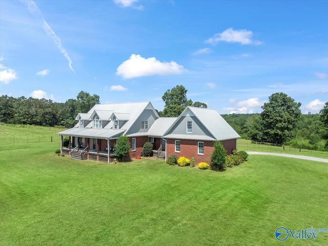 view of front of home featuring a front lawn, covered porch, and brick siding
