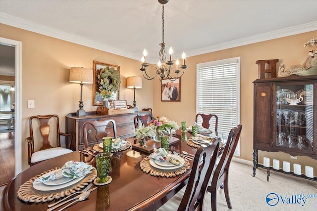 dining space with ornamental molding, baseboards, carpet floors, and a chandelier