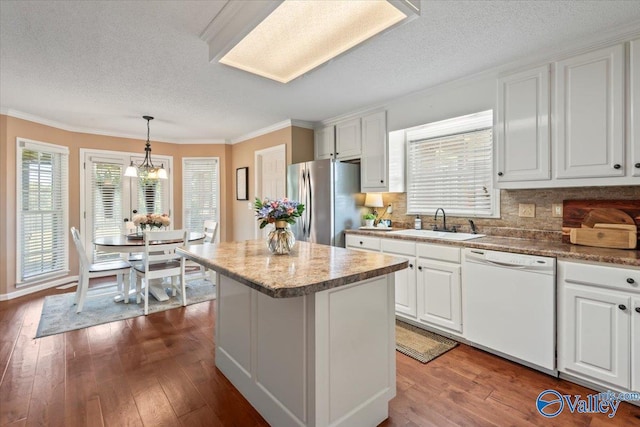 kitchen with dark wood-style floors, dishwasher, freestanding refrigerator, and a sink