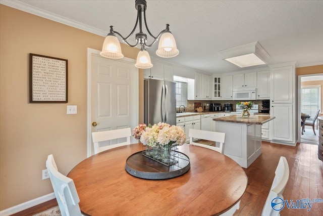dining space with crown molding, dark wood-style floors, and baseboards
