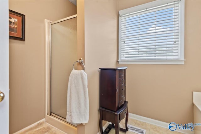 bathroom with visible vents, a stall shower, and baseboards