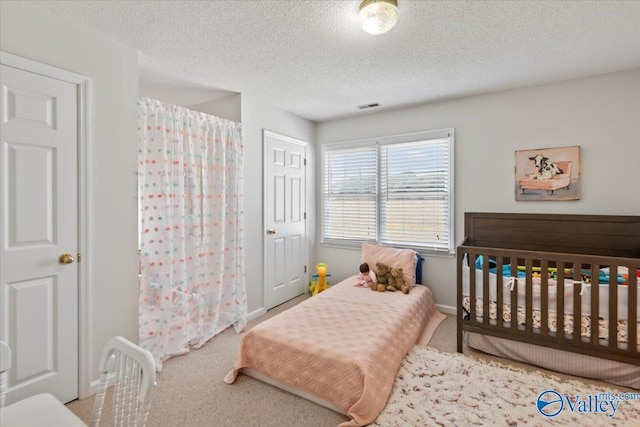 carpeted bedroom with visible vents, baseboards, and a textured ceiling