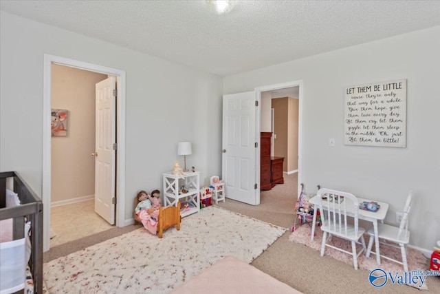 carpeted bedroom with baseboards and a textured ceiling