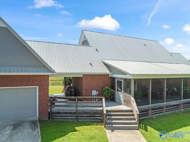 view of front of property featuring brick siding, metal roof, a deck, and a sunroom