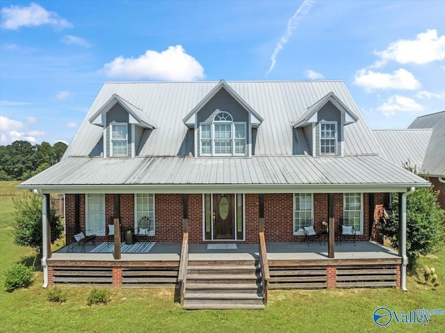 view of front of house featuring brick siding, a porch, and metal roof