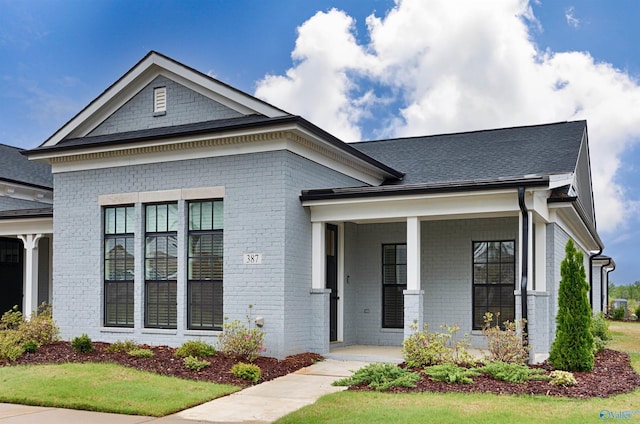 view of front of home featuring a porch and brick siding