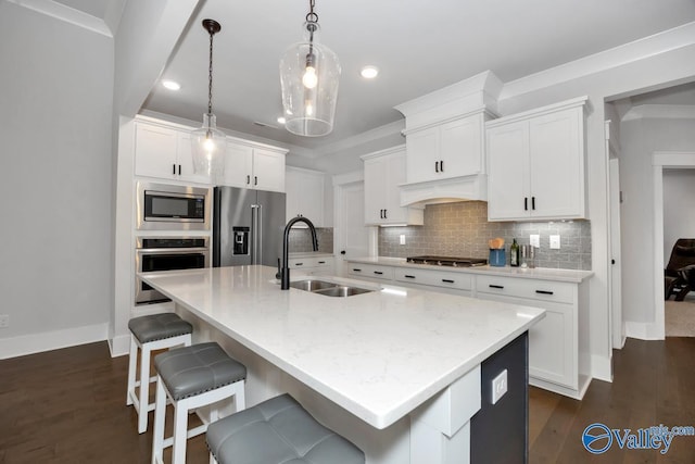 kitchen with a sink, appliances with stainless steel finishes, premium range hood, a kitchen bar, and decorative backsplash