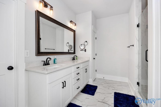 full bath with double vanity, marble finish floor, a sink, and baseboards