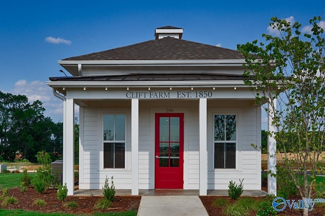 property entrance featuring a shingled roof
