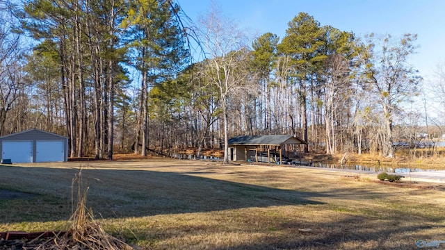 view of yard with a water view, an outbuilding, and a garage