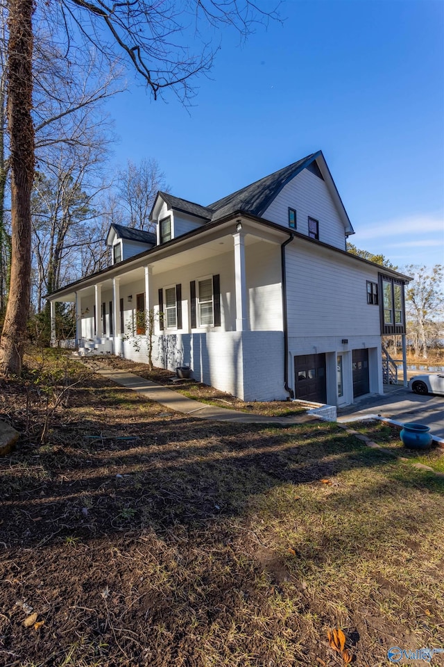 view of property exterior with a garage and a porch