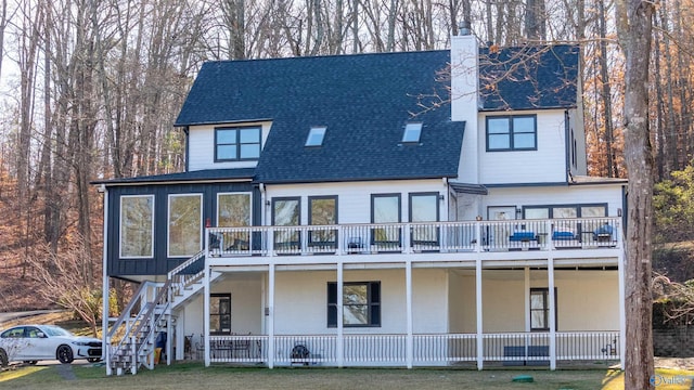 back of house with a balcony and a lawn