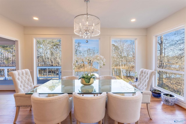 dining space featuring wood-type flooring and an inviting chandelier