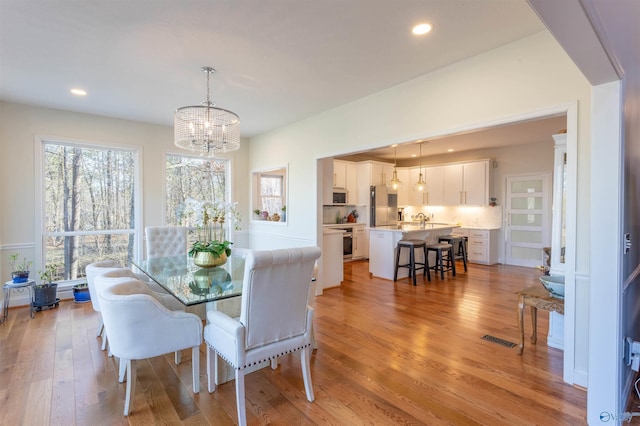 dining room featuring light hardwood / wood-style floors and an inviting chandelier