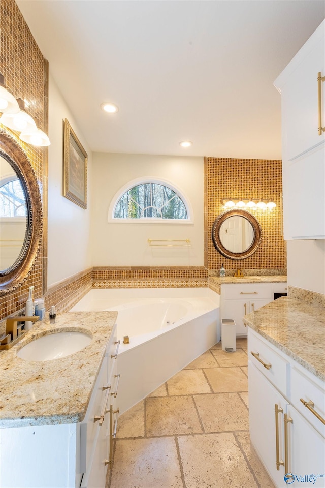 bathroom featuring vanity and a bath