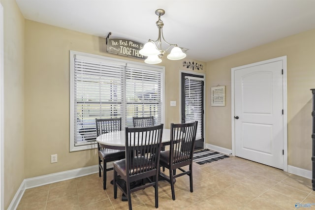 dining area featuring light tile patterned floors, baseboards, and an inviting chandelier