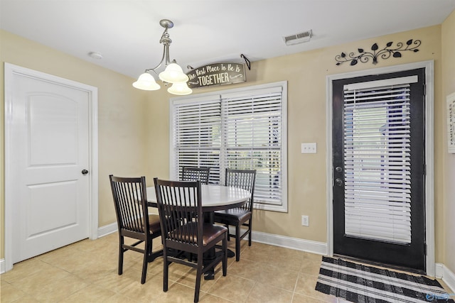 dining space with a chandelier, a healthy amount of sunlight, light tile patterned flooring, and visible vents