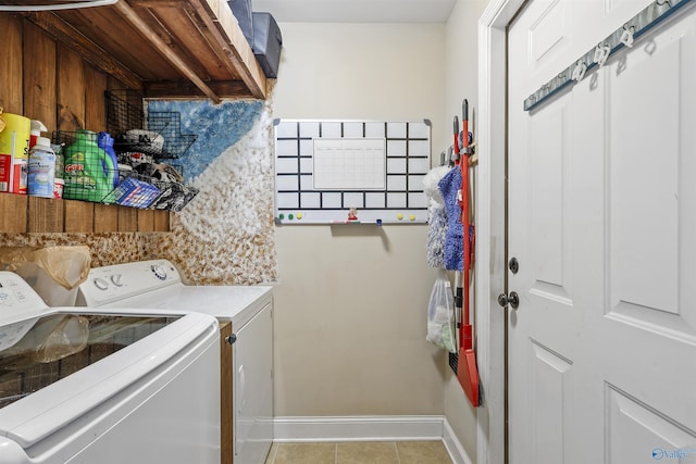 washroom featuring independent washer and dryer, light tile patterned flooring, laundry area, and baseboards