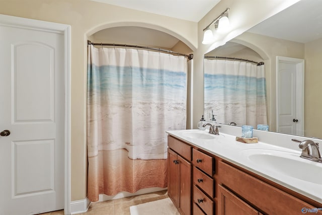 bathroom featuring tile patterned floors, double vanity, and a sink