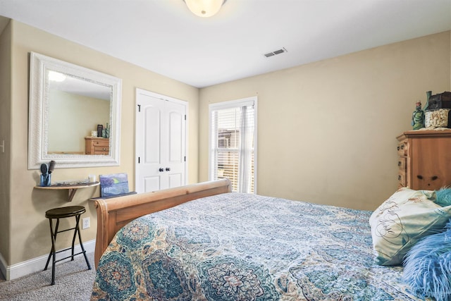 carpeted bedroom with visible vents, baseboards, and a closet