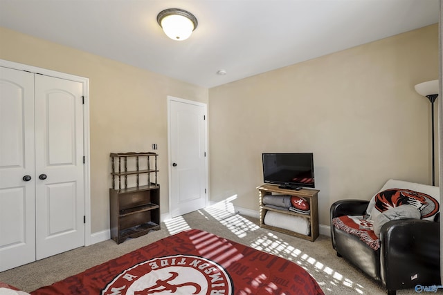 carpeted bedroom with a closet and baseboards
