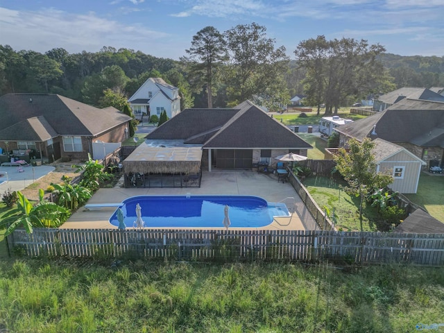 view of pool with a patio, a shed, and a diving board