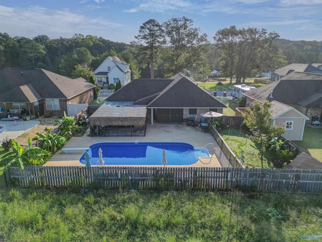 view of swimming pool featuring a patio, a fenced backyard, a fenced in pool, and a diving board