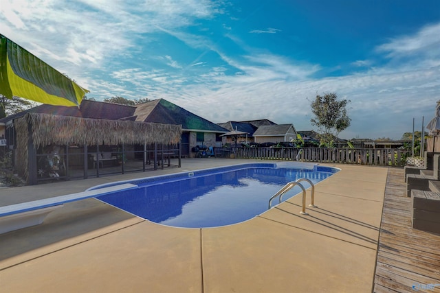 view of swimming pool with a diving board, a patio area, a fenced in pool, and fence