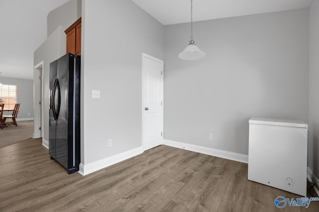 unfurnished dining area featuring lofted ceiling and wood-type flooring