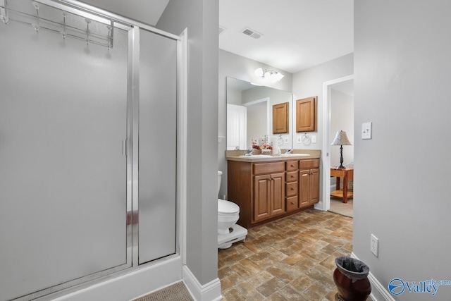 bathroom featuring an enclosed shower, vanity, and toilet