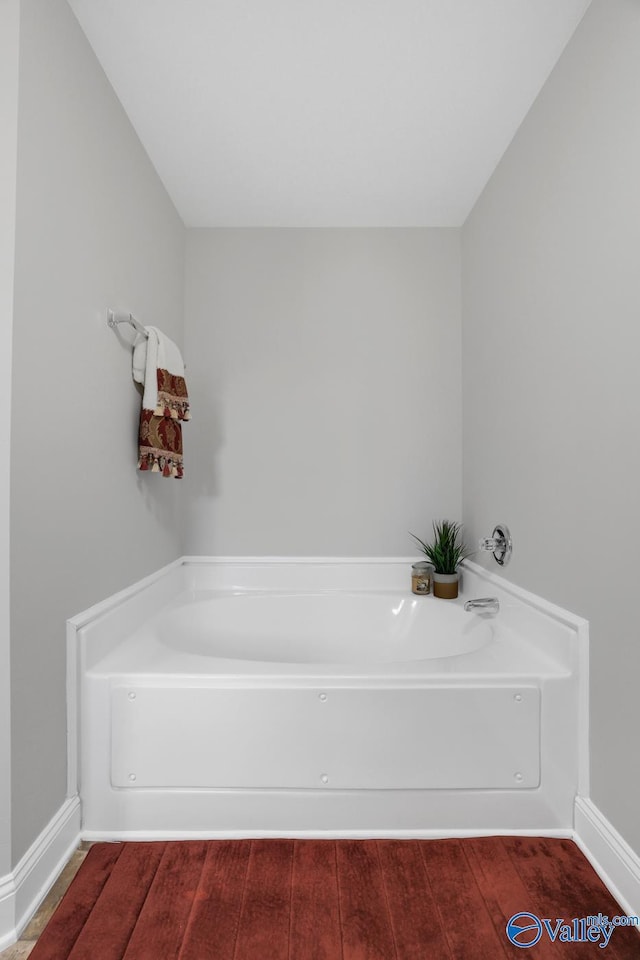 bathroom with a bathtub and hardwood / wood-style floors