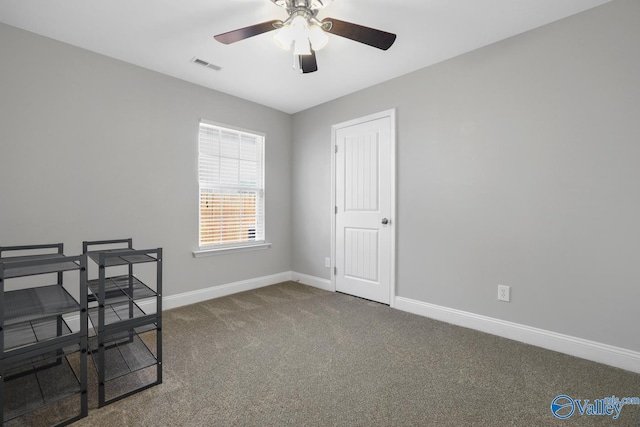 carpeted home office featuring ceiling fan