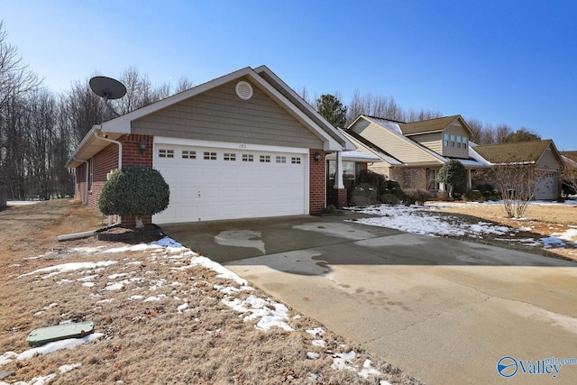 view of front facade with an attached garage, concrete driveway, and brick siding