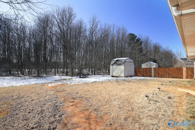 snowy yard featuring a shed