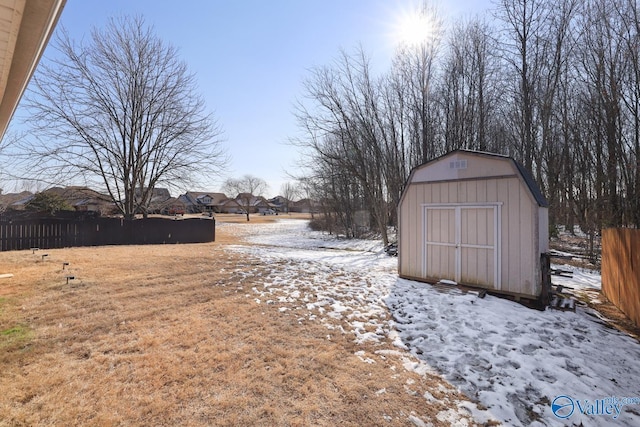 yard covered in snow featuring a shed