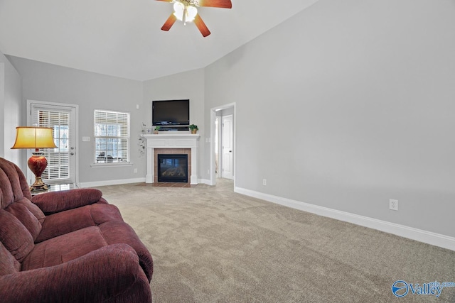 carpeted living room featuring ceiling fan, a tile fireplace, and high vaulted ceiling